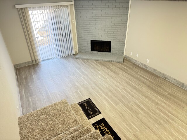 2240 Aspen Dr, Dallas, TX 75227 - unfurnished living room featuring a fireplace, wood finished floors, and baseboards