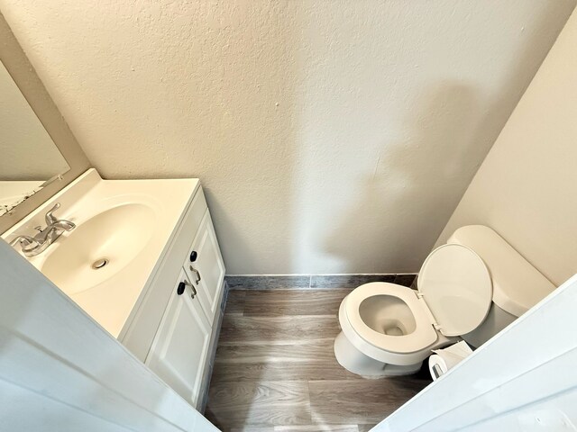 2240 Aspen Dr, Dallas, TX 75227 - half bath featuring vanity, toilet, and wood finished floors