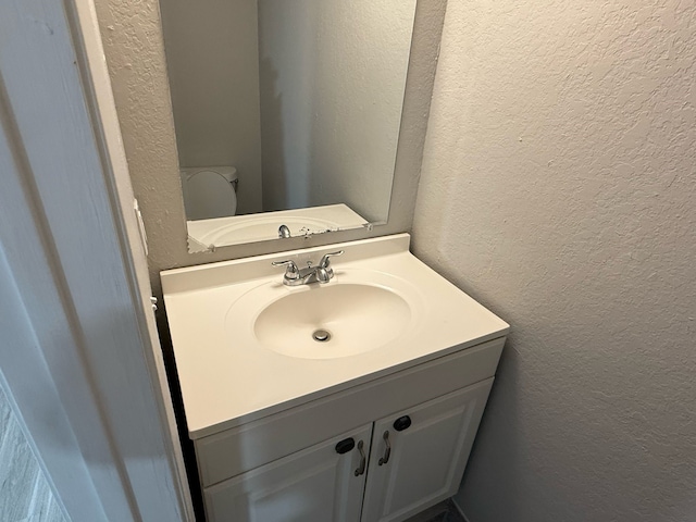 2240 Aspen Dr, Dallas, TX 75227 - half bath with toilet, vanity, and a textured wall