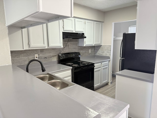 2240 Aspen Dr, Dallas, TX 75227 - kitchen with black appliances, under cabinet range hood, a sink, tasteful backsplash, and light countertops
