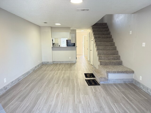 2240 Aspen Dr, Dallas, TX 75227 - stairway with baseboards, wood finished floors, visible vents, and a textured ceiling