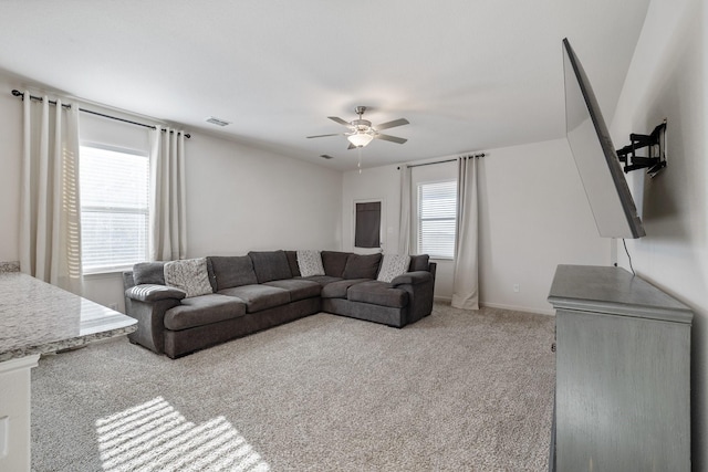 living area featuring ceiling fan, light colored carpet, baseboards, and visible vents
