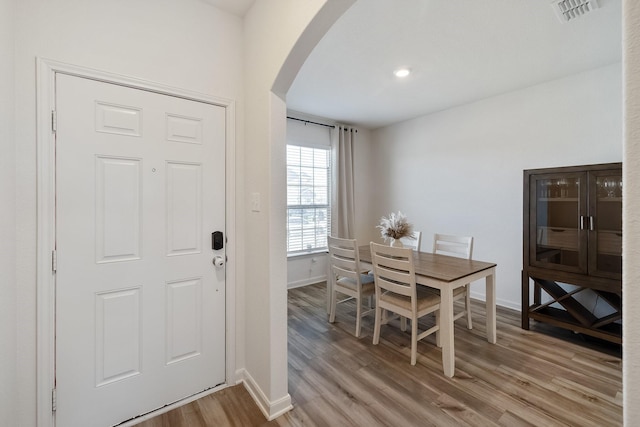 dining space with light wood-style floors, arched walkways, recessed lighting, baseboards, and visible vents