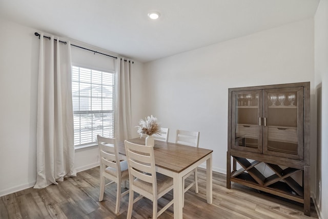 dining area featuring baseboards and light wood-style flooring