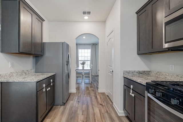 kitchen featuring light wood-style flooring, appliances with stainless steel finishes, and dark brown cabinetry