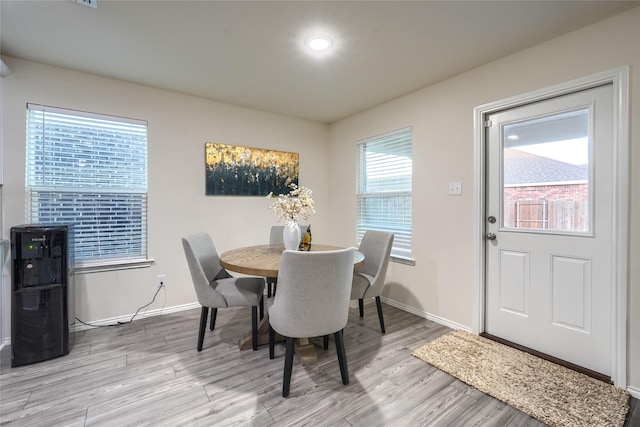 dining room featuring baseboards and light wood finished floors