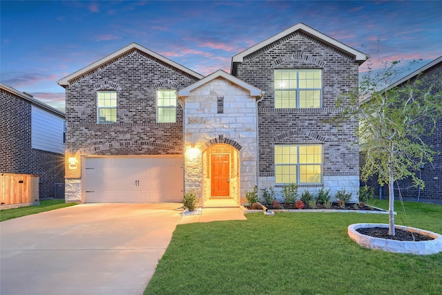 view of front facade with stone siding, concrete driveway, a front yard, a garage, and brick siding