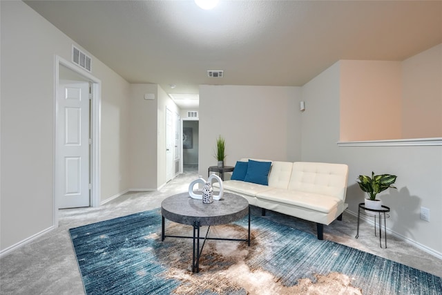 living area featuring baseboards, visible vents, and light carpet