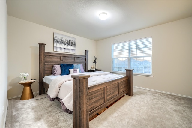 bedroom with light colored carpet and baseboards