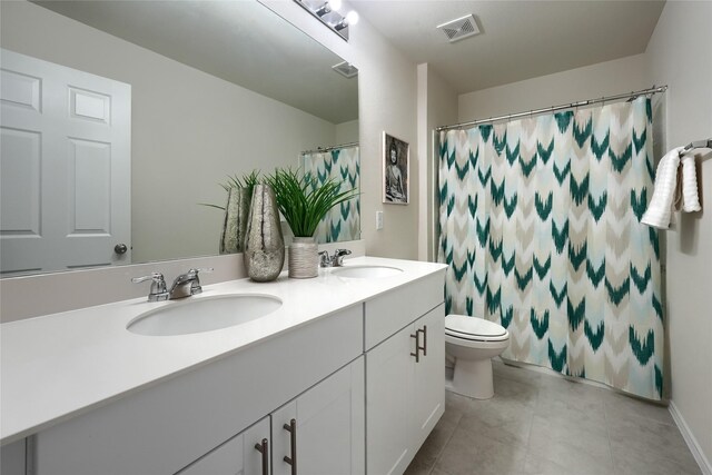 bathroom with double vanity, toilet, visible vents, and a sink