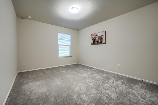 unfurnished room featuring a textured ceiling, baseboards, and carpet