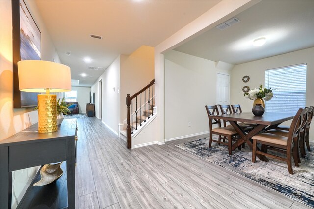 dining area with visible vents, wood finished floors, and stairs