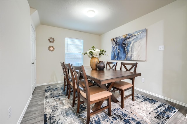 dining area featuring baseboards and wood finished floors