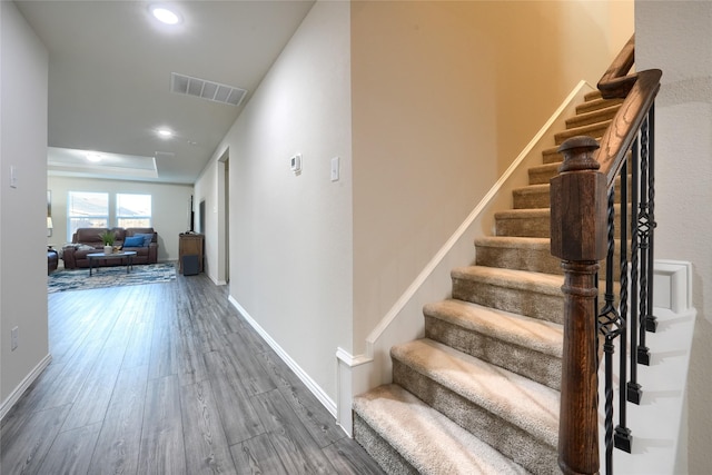 corridor featuring visible vents, baseboards, stairway, recessed lighting, and wood finished floors
