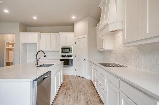 312 Falcon Ct, Springtown, TX 76082 - kitchen with a sink, stainless steel appliances, custom range hood, white cabinetry, and recessed lighting