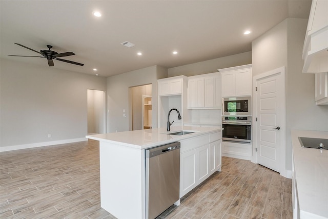 312 Falcon Ct, Springtown, TX 76082 - kitchen featuring stainless steel appliances, a sink, light wood-style flooring, a ceiling fan, and a kitchen island with sink
