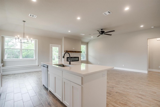 312 Falcon Ct, Springtown, TX 76082 - kitchen with a sink, dishwasher, a glass covered fireplace, recessed lighting, and ceiling fan