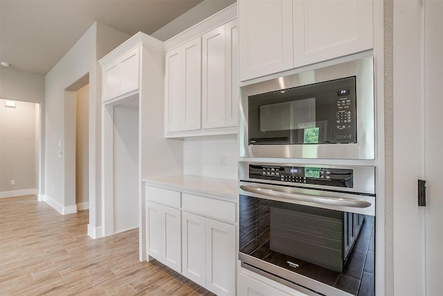 312 Falcon Ct, Springtown, TX 76082 - kitchen with stainless steel appliances, white cabinets, baseboards, light wood-style flooring, and light countertops