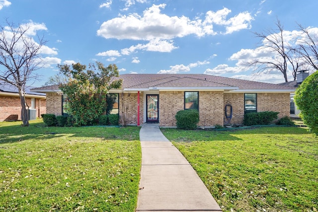 single story home featuring brick siding, central air condition unit, and a front yard
