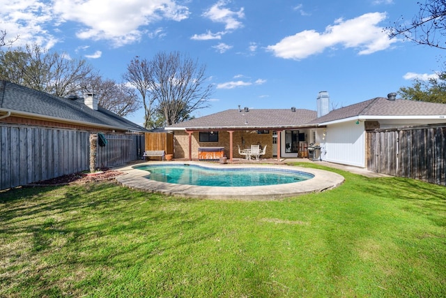 view of swimming pool featuring a lawn, a patio, a fenced backyard, and area for grilling