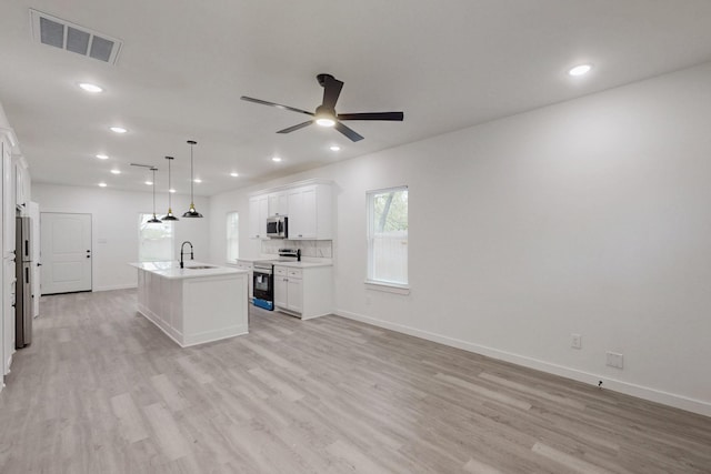 kitchen featuring a ceiling fan, a sink, light wood-type flooring, stainless steel appliances, and visible vents