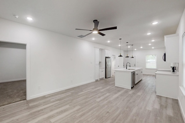kitchen featuring a ceiling fan, a sink, open floor plan, stainless steel appliances, and visible vents
