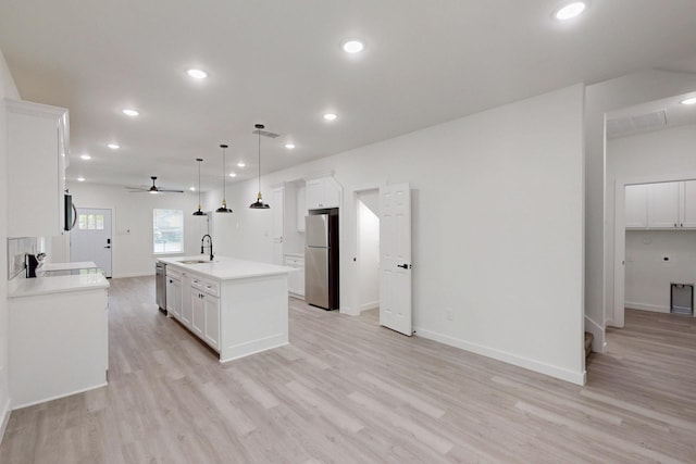 kitchen featuring light wood finished floors, stainless steel appliances, and a sink