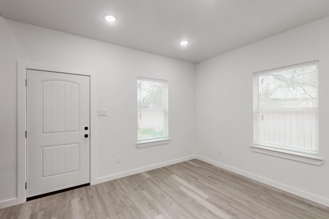 interior space with baseboards, recessed lighting, and light wood-style floors