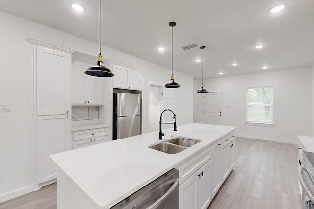 kitchen featuring a sink, light wood-style floors, light countertops, appliances with stainless steel finishes, and visible vents