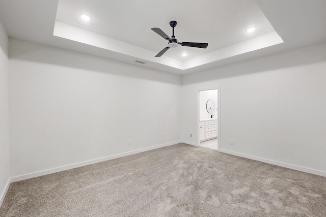 carpeted empty room with baseboards, visible vents, recessed lighting, and a raised ceiling