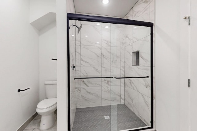 full bathroom featuring a shower stall, toilet, and baseboards