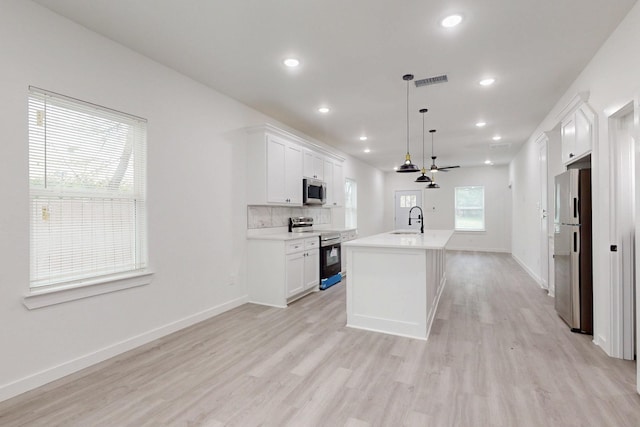 kitchen with light wood-type flooring, visible vents, appliances with stainless steel finishes, and a sink