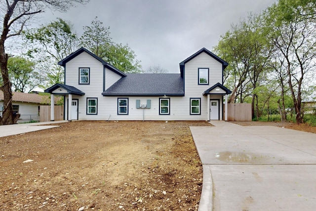 modern inspired farmhouse with fence, a shingled roof, and concrete driveway