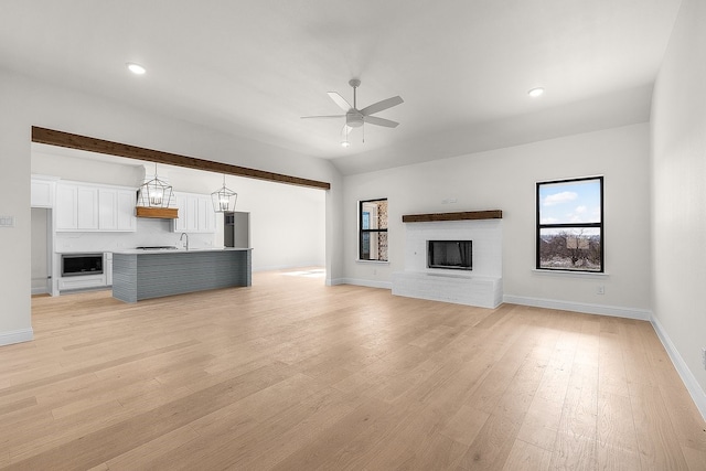 405 Red Roan Rdg, Brock, TX 76087 - unfurnished living room featuring light wood finished floors, baseboards, ceiling fan, vaulted ceiling, and a fireplace