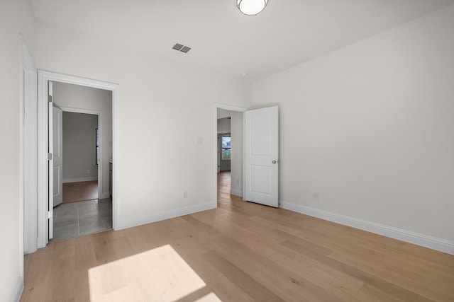 405 Red Roan Rdg, Brock, TX 76087 - unfurnished bedroom with visible vents, light wood-type flooring, and baseboards