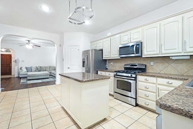2725 Albatross Ln, Fort Worth, TX 76177 - kitchen with stainless steel appliances, arched walkways, ceiling fan, tasteful backsplash, and light tile patterned flooring