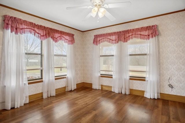 unfurnished dining area featuring wood finished floors, ornamental molding, and wallpapered walls