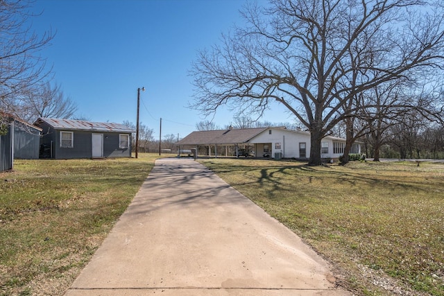 view of front of property featuring concrete driveway and a front lawn