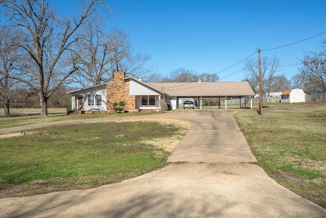 view of front facade featuring a chimney, concrete driveway, and a front lawn