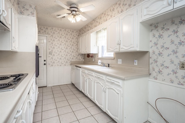kitchen featuring stainless steel stovetop, ceiling fan, wainscoting, and wallpapered walls