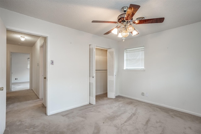 unfurnished bedroom with carpet floors, a textured ceiling, baseboards, and a closet