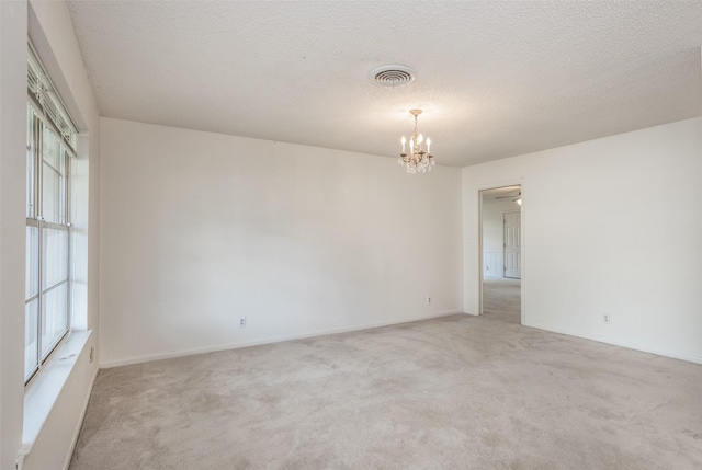 empty room with light colored carpet, visible vents, and a wealth of natural light