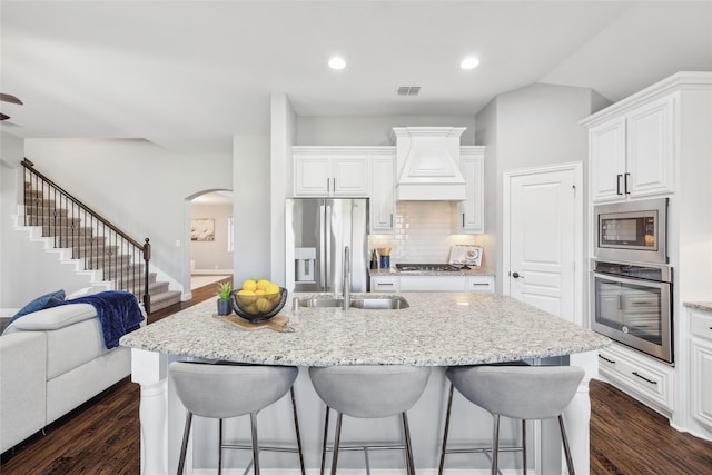 9413 Lakeway Dr, Denton, TX 76226 - kitchen with stainless steel appliances, custom exhaust hood, a sink, open floor plan, and arched walkways