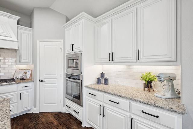 9413 Lakeway Dr, Denton, TX 76226 - kitchen featuring appliances with stainless steel finishes, backsplash, white cabinetry, light stone countertops, and dark wood finished floors