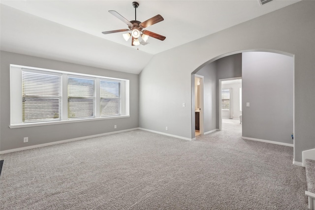 9413 Lakeway Dr, Denton, TX 76226 - spare room with arched walkways, a ceiling fan, light carpet, vaulted ceiling, and baseboards
