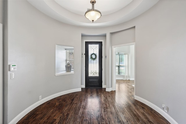 foyer with dark wood-type flooring and baseboards