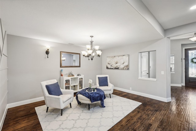 living area with dark wood-type flooring, baseboards, and a notable chandelier