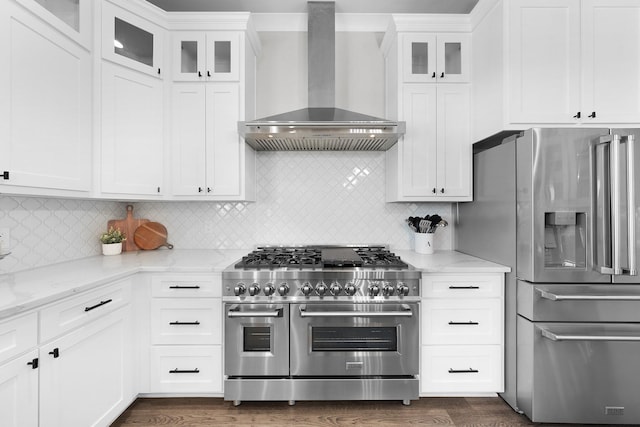 kitchen with white cabinets, appliances with stainless steel finishes, wall chimney exhaust hood, and dark wood-type flooring