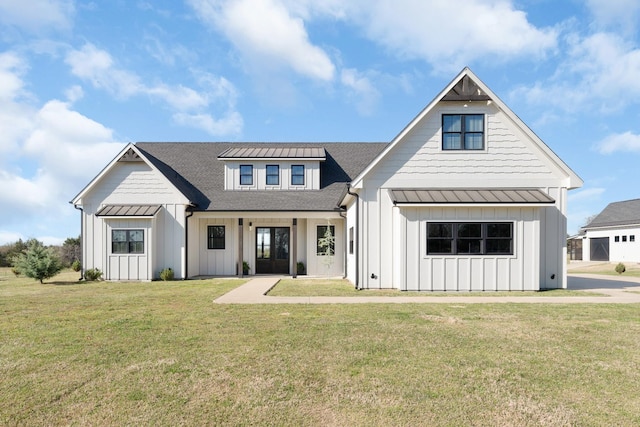 modern inspired farmhouse with board and batten siding, a shingled roof, and a front yard