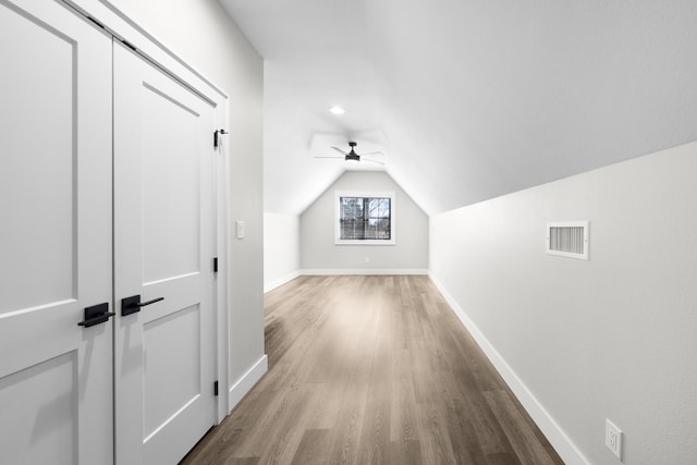 bonus room with visible vents, a ceiling fan, wood finished floors, baseboards, and vaulted ceiling